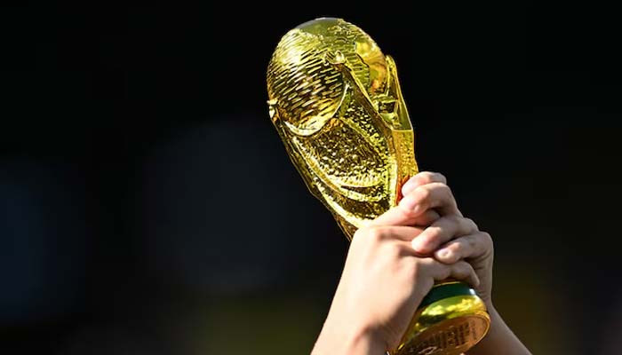 A fan holds up a replica of the FIFA World Cup trophy. — Reuters