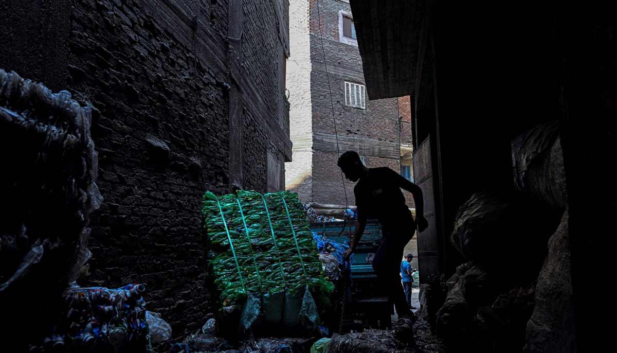 Egyptian workers load bails of plastic for recycling on a truck at the garbage city in the Manshiyet Nasser neighbourhood in Cairo on July 6, 2026.— AFP