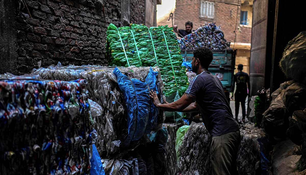 Egyptian workers load bails of plastic for recycling on a truck at the garbage city in the Manshiyet Nasser neighbourhood in Cairo on July 6, 2026.— AFP