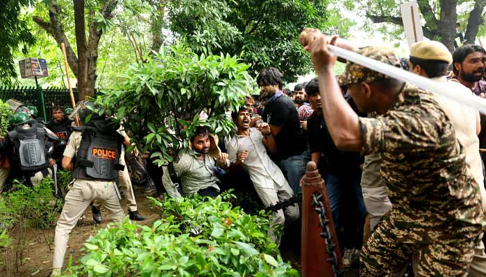 A security force personnel wields his baton against demonstrators at a protest site during a planned march by supporters of Indias Cockroach Janta Party towards parliament on the opening day of its monsoon session, demanding the resignation of Education Minister Dharmendra Pradhan over exam paper leaks near Jantar Mantar, New Delhi, India, July 20, 2026.— Reuters