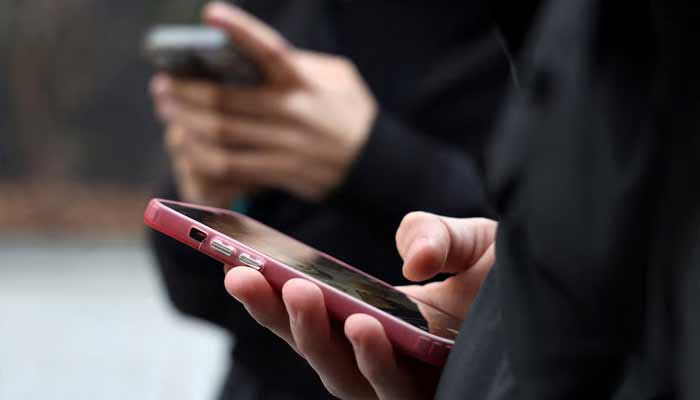 Teenagers look at their mobile phone screens during an interview with Reuters about the bill aimed at banning the use of social networks for those under 15 and mobile phones in high schools from the start of the 2026 school year, in Paris, France, February 20, 2026. — Reuters