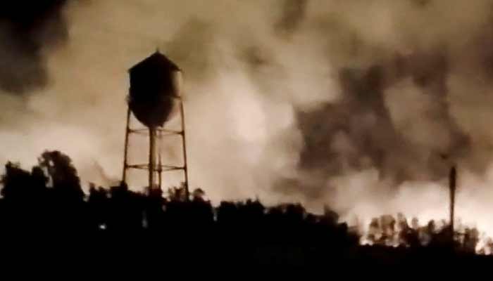 A water tower is silhouetted against smoke rising from a fire following a reported strike in Behbahan, Khuzestan Province, Iran. — Reuters
