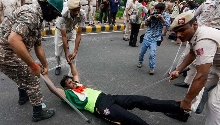 Police confront a protester lying on the ground as supporters of the Cockroach Janta Party march on parliament on the opening day of its monsoon session, demanding the resignation of Education Minister Dharmendra Pradhan over exam paper leaks, in New Delhi, India, 20 July, 2026.