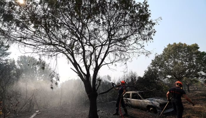 French firefighters spray water during mop-up operations near a burnt house and a burnt car in an area affected by a wildfire in Cotignac, in the Var department, as drought conditions worsen following a heatwave and water shortages across much of France, July 22, 2026. — Reuters