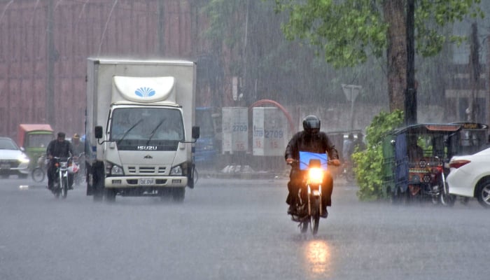 Commuters pass through a road during monsoon rain in Lahore, July 22, 2026. — Online