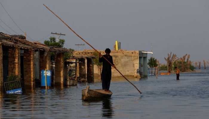A man rows his boat as he passes through a flooded market, following rains and floods during the monsoon season in Bajara village, at the banks of Manchar lake, in Sehwan, September 6, 2022.  — Reuters