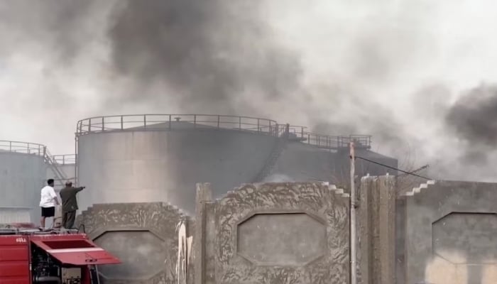 A person gestures towards smoke rising in the aftermath of a Saudi-led coalition airstrike in Yemens southern port of Mukalla, in this screengrab from a handout video obtained by Reuters on December 30, 2025. — Reuters