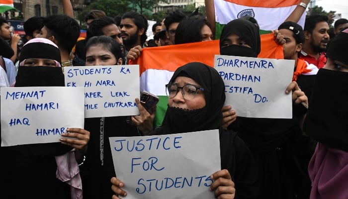 Demonstrators holding Indian national flags and placards take part in a protest rally in Kolkata on July 24, 2026. — AFP