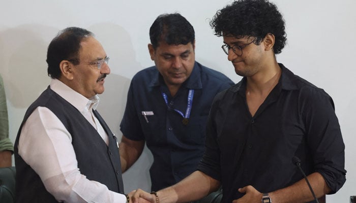 Saurav Das, spokesperson from Cockroach Janta Party (CJP) shakes hands with JP Nadda, India’s senior federal ministers, after Indias Education Minister Dharmendra Pradhan resigned, following days of protests demanding his resignation over National Eligibility cum Entrance Test (NEET) examination paper leaks. — Reuters