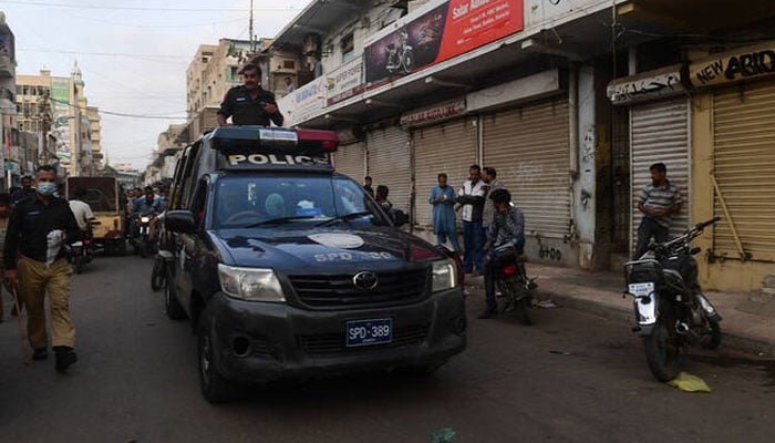 Police patrol through a closed market in Karachi on May 27, 2021. — AFP