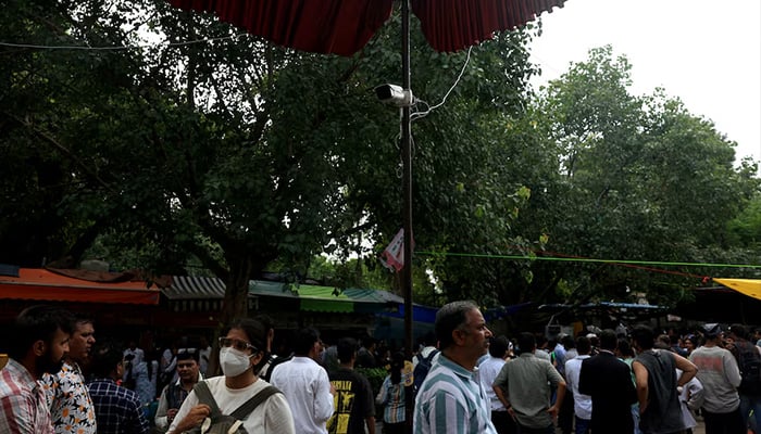 Supporters of Indias Cockroach Janta Party (CJP) move past a CCTV camera at the ongoing protest site, days after thousands of protesters marched towards parliament demanding the resignation of Education Minister Dharmendra Pradhan over National Eligibility cum Entrance Test (NEET) examination paper leaks, at Jantar Mantar in New Delhi, July 24, 2026. — Reuters