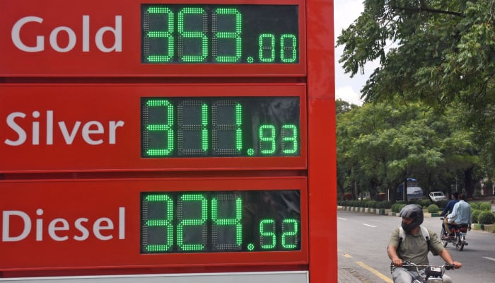A motorcyclist rides past the price board of a fuel station in Islamabad on July 11, 2026. — Online