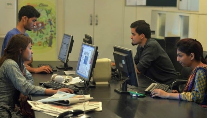 Staff work on their computers at an office in Islamabad on July 26, 2016. — AFP