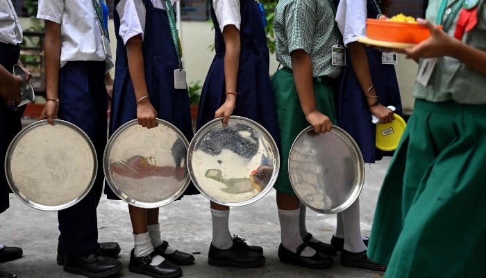 Students queue up to receive mid-day meals at a government primary school in Kolkata on July 9, 2026. — AFP