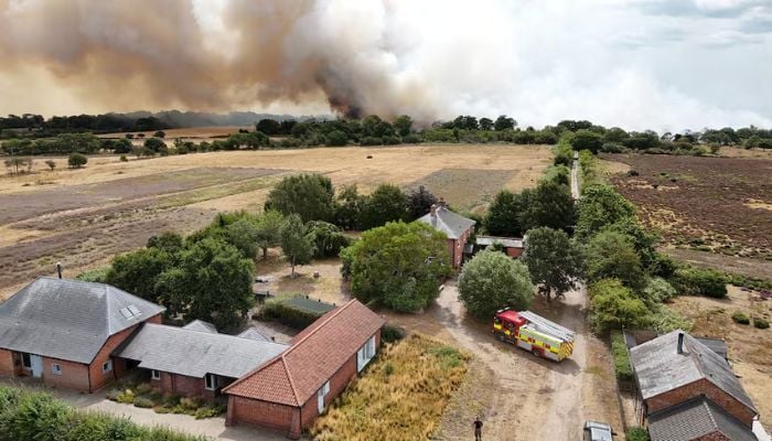A drone view shows smoke rising in the distance as firefighters tackle a wildfire at Dunwich Heath, near Dunwich, Britain, where a major incident is in place after a coastal heathland blaze started on Wednesday afternoon, in one of the seven areas affected by drought conditions declared by Britains Environment Agency, July 30, 2026. REUTERS/Marissa Davison