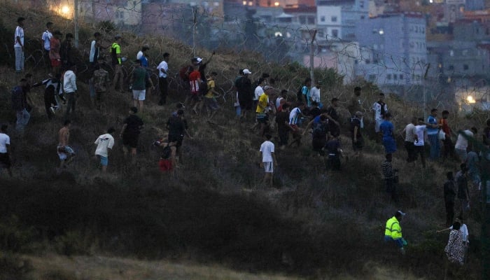People gather on a hilltop near Bab Sebta on the Morocco-Spain border, near Spain´s enclave of Ceuta and the Moroccan town of Fnideq on July 30, 2026. — AFP