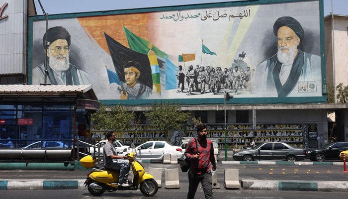 People walk past a mural depicting the late leader of the Islamic Revolution, Ayatollah Ruhollah Khomeini, and Irans late Supreme Leader Ayatollah Ali Khamenei, on a street in Tehran, Iran, July 30, 2026.— Reuters