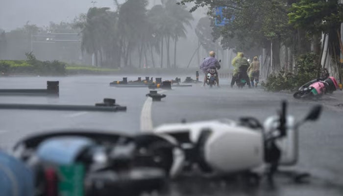 People ride electric scooters amid strong wind and heavy rainfall brought by Typhoon Matmo, in Haikou, Hainan province, China October 5, 2025. — Reuters