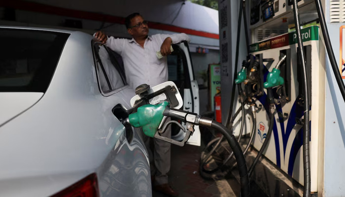 A man checks the fuel dispenser display as his car is being filled with petrol at a fuel station in New Delhi, India, August 3, 2026. — Reuters