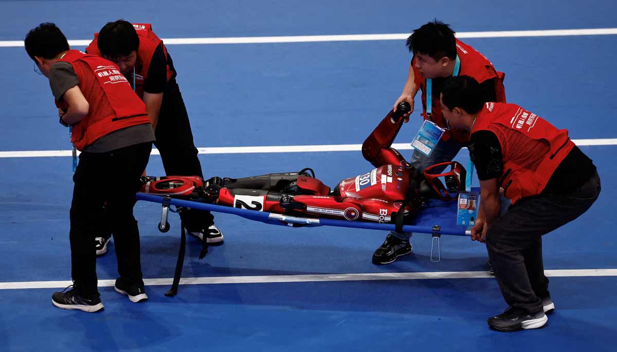 Staff members use a stretcher to move a humanoid robot after it fell during a 100m large-sized group preliminary race, following the opening ceremony of the 2026 World Humanoid Robot Games, at the National Speed Skating Oval, in Beijing, China, on August 22.— Reuters