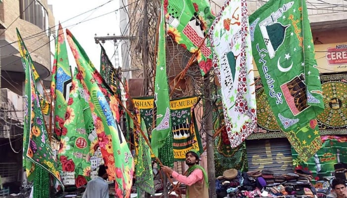 A vendor arranging and displaying decorative stuff to attract customers in Larkana in connection with Eid Milad-un-Nabi (Peace Be Upon Him). — APP/File