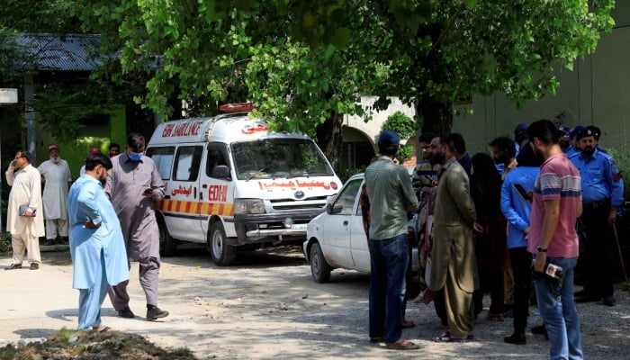 Family members and police officers stand outside a mortuary following a deadly fire at the Pakistan Institute of Medical Sciences (Pims) hospital in Islamabad, August 26, 2026. — Reuters