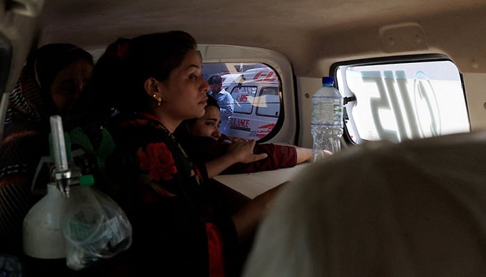 Javeria, mother of a newborn victim, holds onto a coffin containing the body of her newborn inside an ambulance following a deadly fire at the Pakistan Institute of Medical Sciences (PIMS) hospital in Islamabad, August 26, 2026. — Reuters