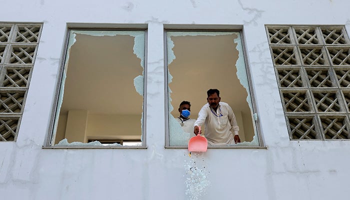 A worker removes broken pieces of a glass window after a fire broke out at the Pakistan Institute of Medical Sciences (Pims) hospital in Islamabad, August 26, 2026. — Reuters