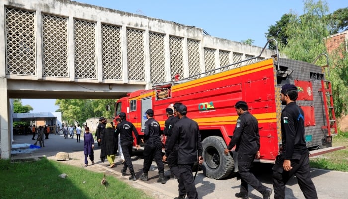Members of Anti-Terrorist Squad move past a fire engine following a deadly fire at the Pakistan Institute of Medical Sciences (PIMS) hospital in Islamabad, August 26, 2026. — Reuters