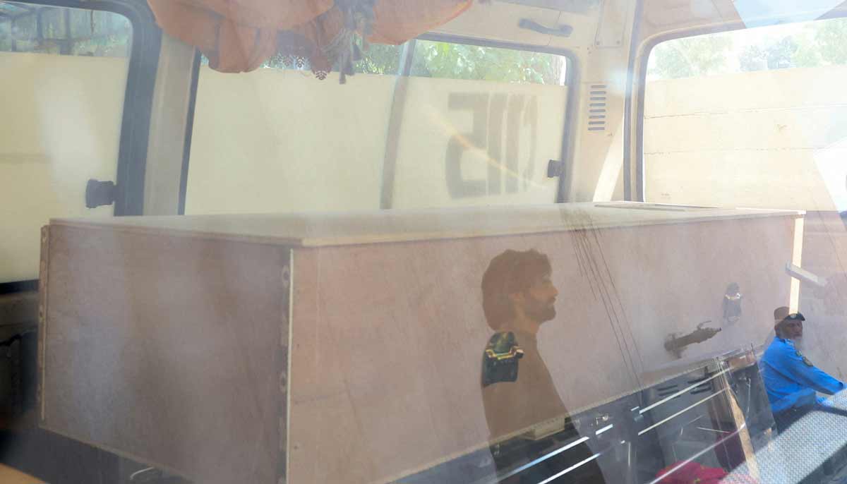 Men are reflected in the glass window of an ambulance as a coffin carrying a victim is placed inside, following a deadly fire at the Pakistan Institute of Medical Sciences hospital in Islamabad, August 26, 2026.— Reuters