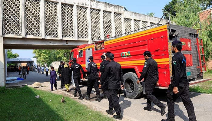 Members of Anti-Terrorist Squad move past a fire engine following a deadly fire at the Pakistan Institute of Medical Sciences (PIMS) hospital in Islamabad, August 26, 2026. — Reuters