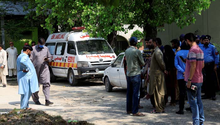 Family members and police officers stand outside a mortuary following a deadly fire at the Pakistan Institute of Medical Sciences (PIMS) hospital in Islamabad, Pakistan, August 26, 2026. — Reuters