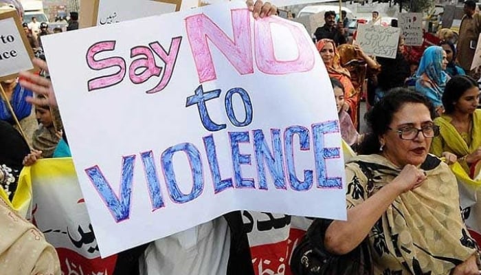 A person holds a placard against violence towards women during a protest. — AFP/File