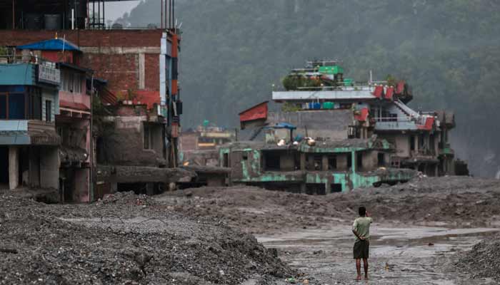A man takes pictures in front of damaged buildings after flash floods and a mudslide, in Trishuli, Nuwakot district, Nepal, August 29, 2026.— Reuters