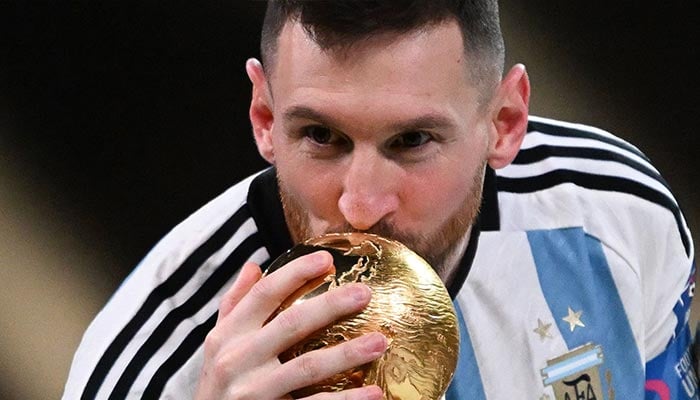 Argentinas captain and forward #10 Lionel Messi kisses the FIFA World Cup Trophy during the trophy ceremony after Argentina won the Qatar 2022 World Cup final football match between Argentina and France at Lusail Stadium in Lusail, Doha on December 18, 2022. — AFP
