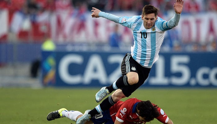 Argentinas forward Lionel Messi (top) vies for the ball with Chiles midfielder Jorge Valdivia during their 2015 Copa America football championship final, in Santiago, Chile, on July 4, 2015. — AFP