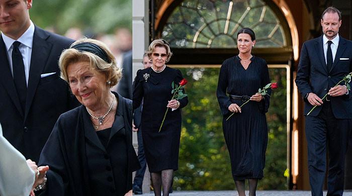 Queen Sonja takes poignant pause before King Harald's sea of flowers