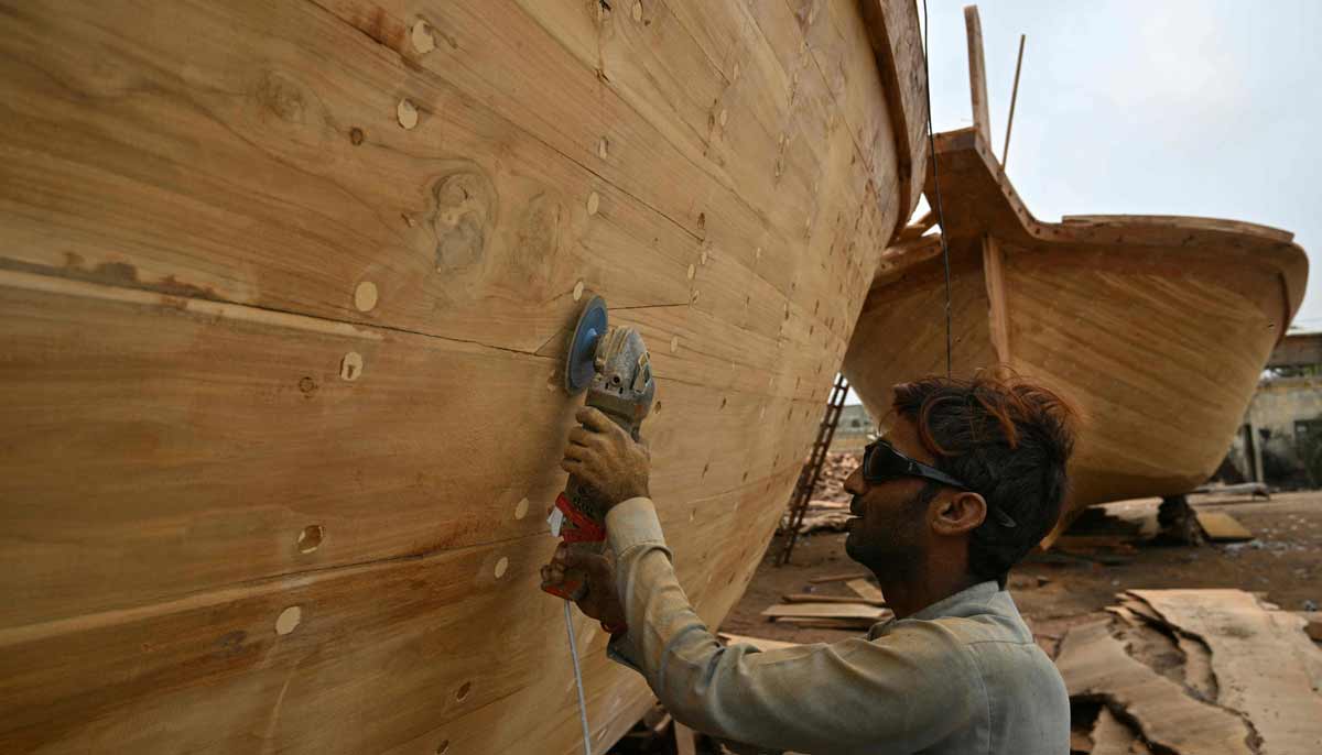 Craftsman Muhammad Asif is building a traditional wooden boat in a yard in Ibrahim Hyderi in Karachi. — AFP