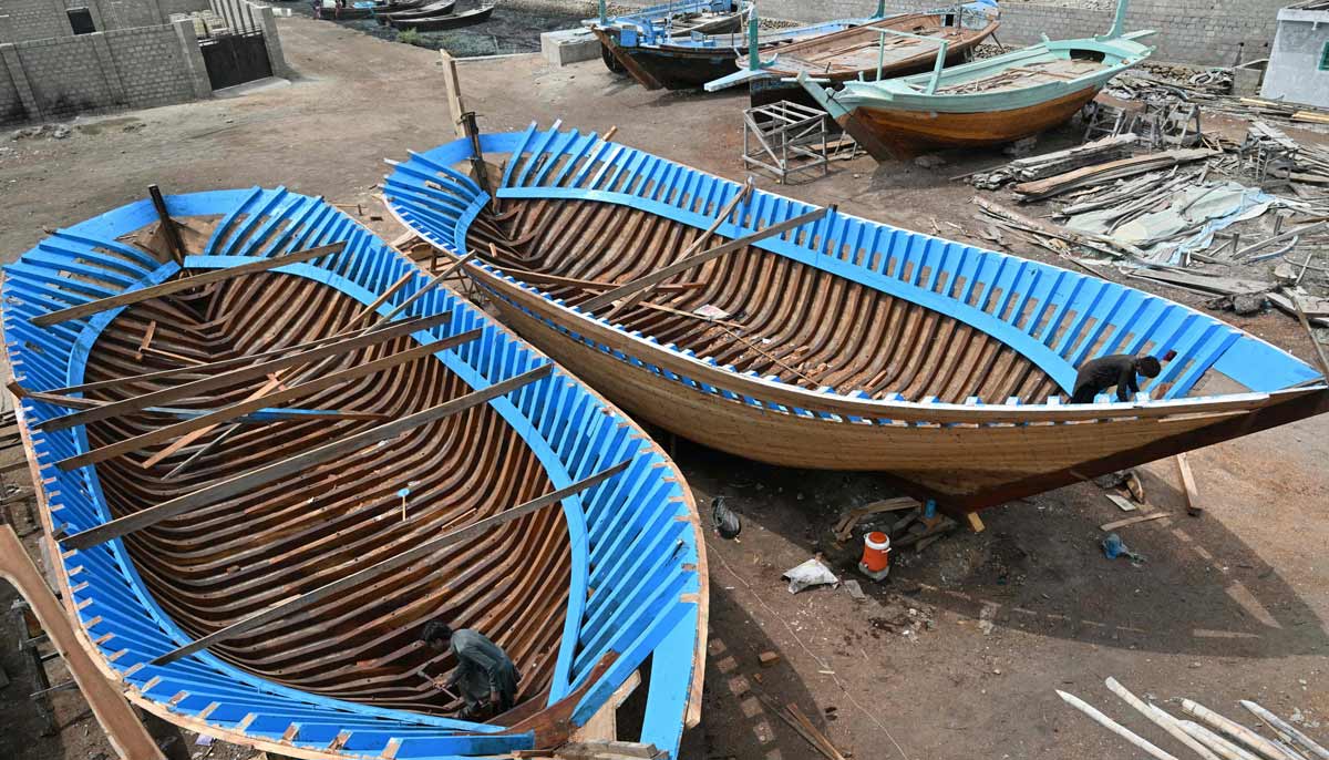 Workers building traditional wooden boats at a yard in Ibrahim Hyderi in Karachi.— AFP