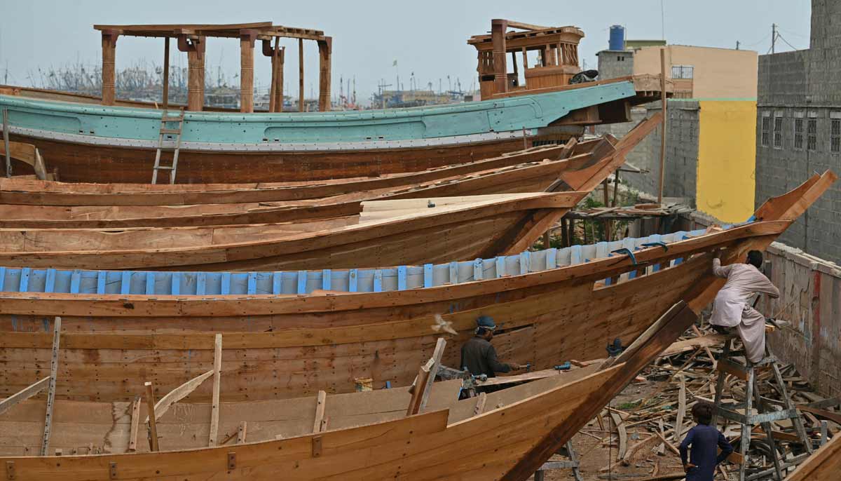 Workers building traditional wooden boats at a yard in Ibrahim Hyderi in Karachi.— AFP