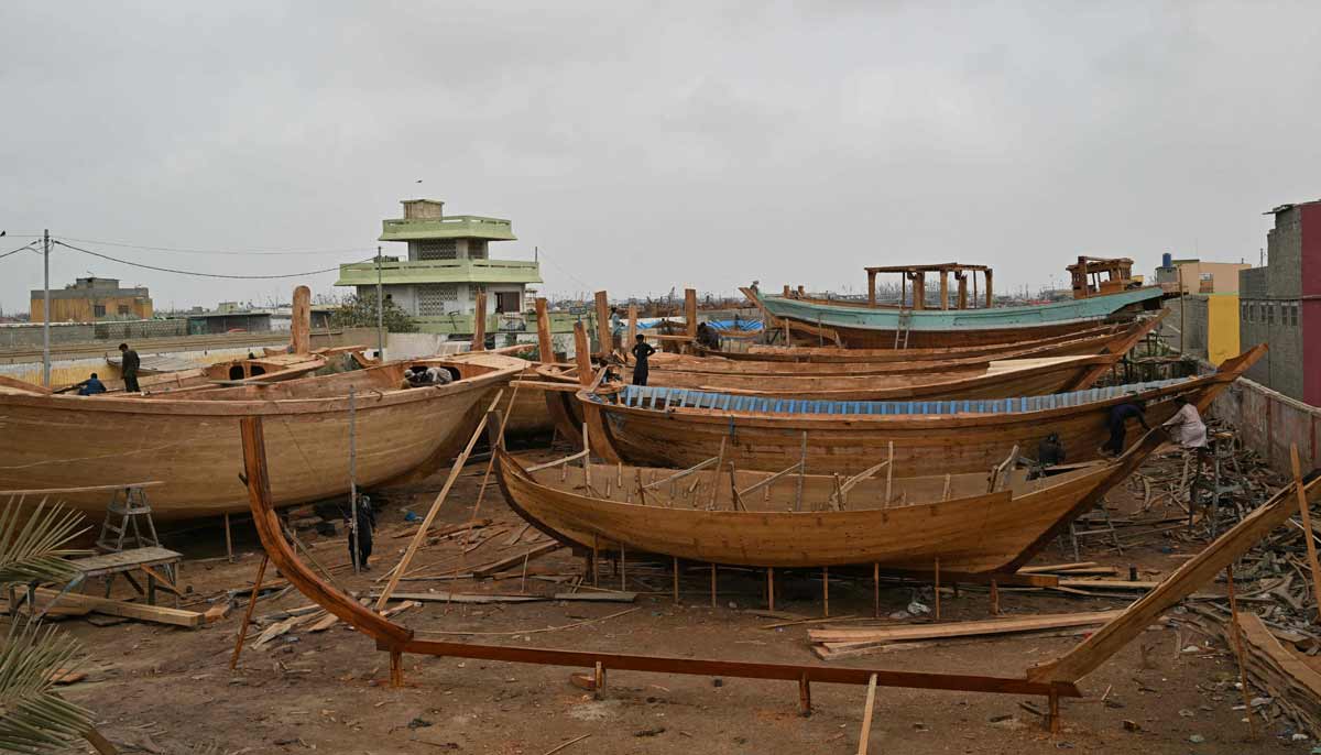 Workers building traditional wooden boats at a yard in Ibrahim Hyderi in Karachi.— AFP