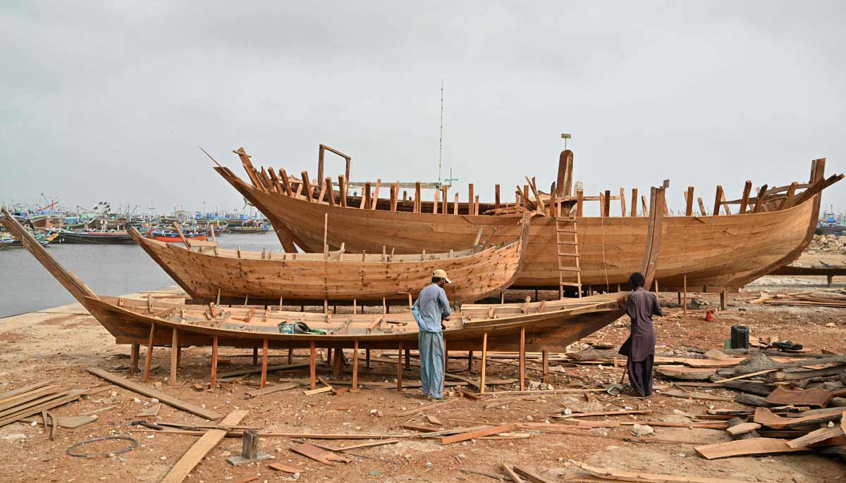 Workers building traditional wooden boats at a yard in Ibrahim Hyderi in Karachi.— AFP
