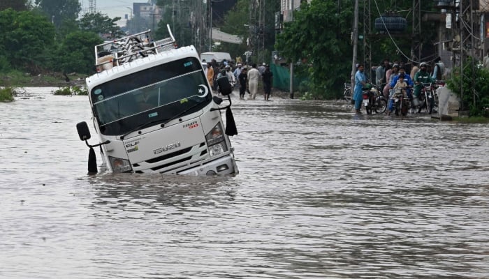A van is seen stuck amid a flooded street after heavy monsoon rainfall in Islamabad on September 1, 2026. — AFP