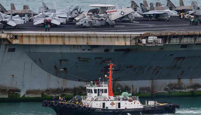 A tugboat guides the US nuclear-powered aircraft carrier USS Abraham Lincoln (CVN-72) towards Laem Chabang Port, near the city of Pattaya on September 2, 2026.— AFP