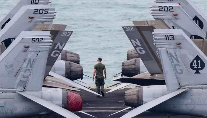 A crew member walks on the flight deck of US nuclear-powered aircraft carrier USS Abraham Lincoln (CVN-72) as it heads towards Laem Chabang Port, near the city of Pattaya on September 2, 2026.— AFP