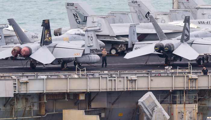 A crew member stands on the flight deck of US nuclear-powered aircraft carrier USS Abraham Lincoln (CVN-72) as it heads towards Laem Chabang Port, near the city of Pattaya on September 2, 2026. — AFP
