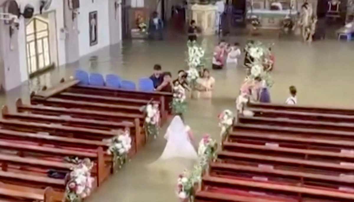 The bride Lhiane Galang walking down the aisle at the St. John the Baptist Parish church during their wedding ceremony in a flooded church in Hagonoy town.— AFP