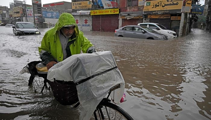 Commuters wade through a flooded street after heavy monsoon rainfall in Rawalpindi on September 1, 2026. — AFP