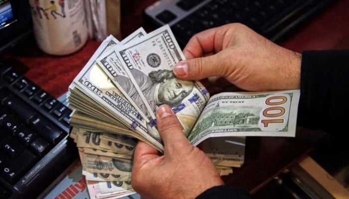 A money changer counts US dollar banknotes at a currency exchange office in Ankara, Turkey November 11, 2021. — Reuters