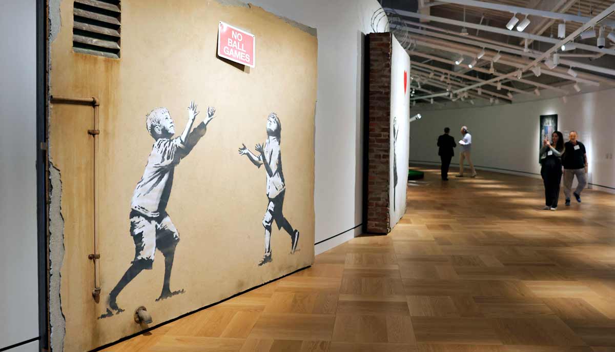 Visitors walk by pieces created by Banksy at the new Lucas Museum of Narrative Art. — AFP